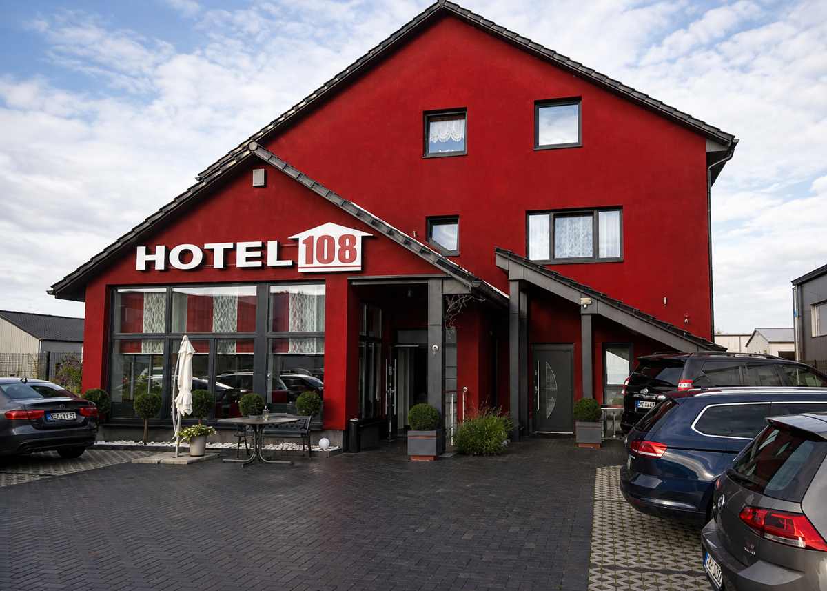 Kostenfreie private Parkplätze vor dem roten Gebäude des Hotel 108 in Glinde